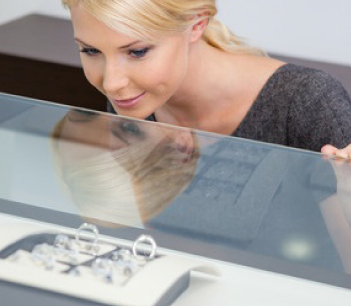 woman looking at rings in jewelry shop case