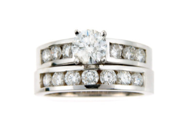 Brilliant cut diamond bridal ring set with channel set side stones in white gold.