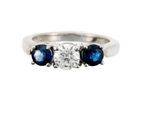 Brilliant cut diamond engagement ring with sapphire side stones in white gold.