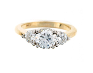 Brilliant cut diamond engagement ring with side stones in yellow gold.