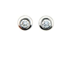 Round bezel set diamond stud earring in platinum.